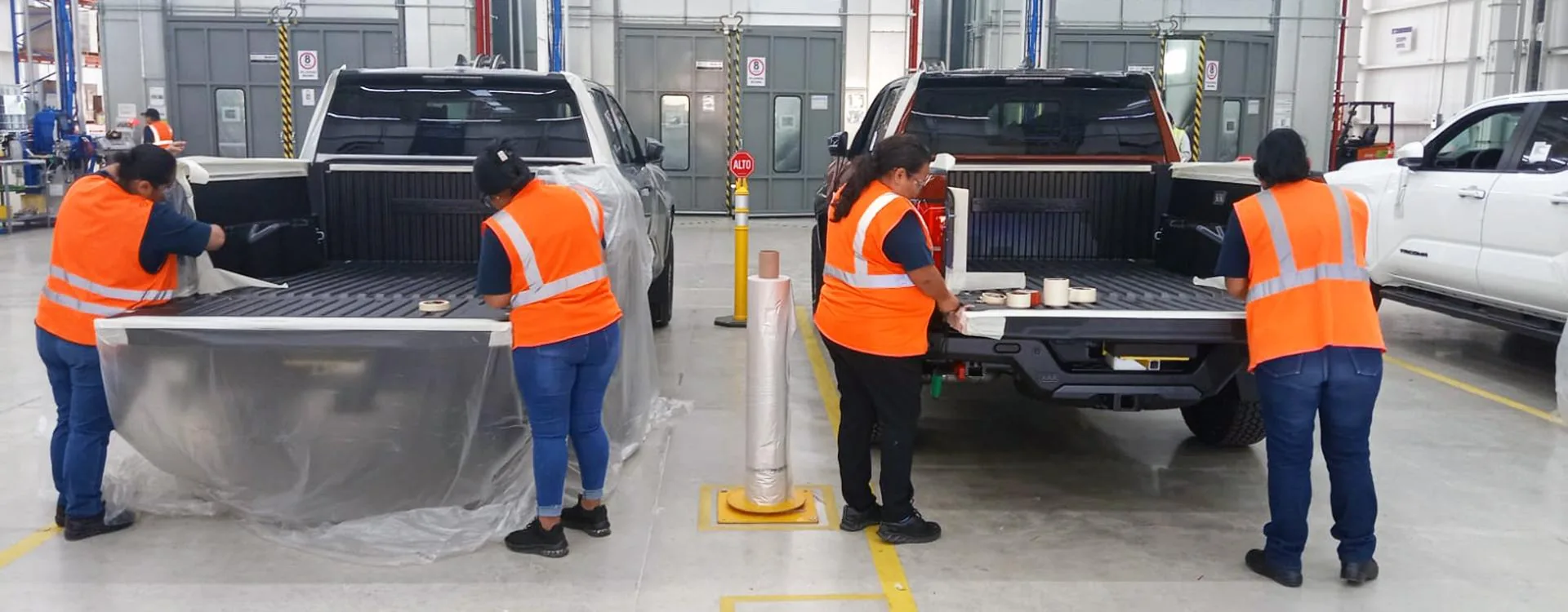 GFX Solutions team members installing and masking bedliners on the production line