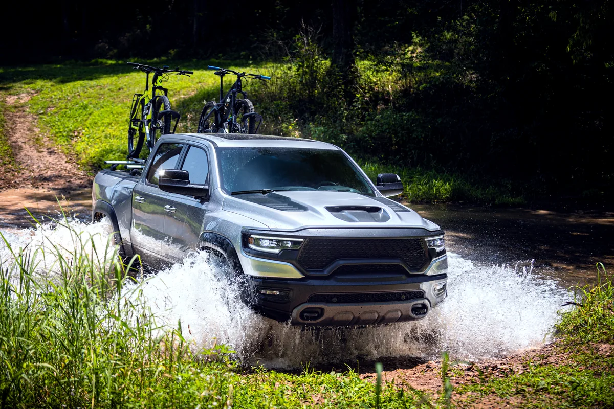 LINE-X-equipped truck fording water with mountain bikes mounted on a roof rack