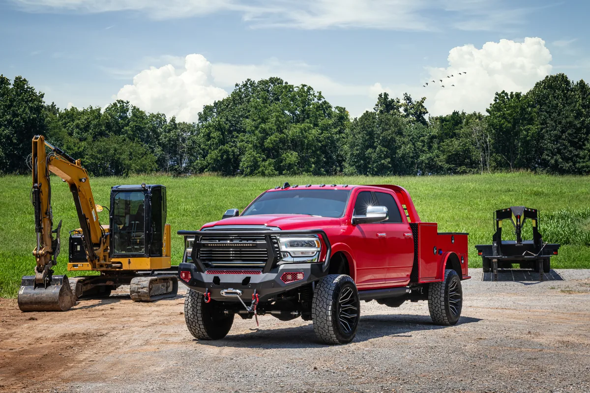 LINE-X-equipped work truck with excavator and trailer at a job site