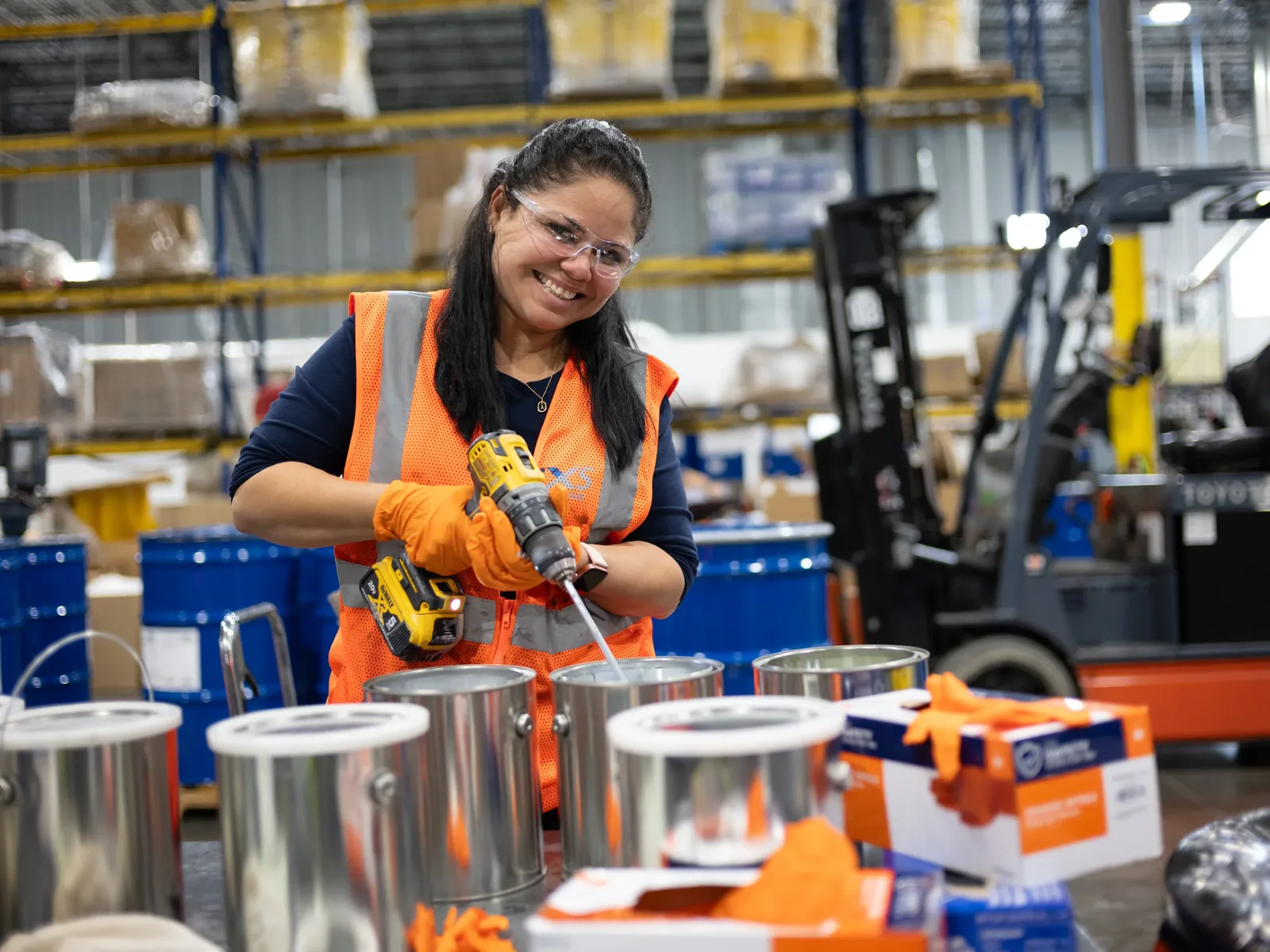 IXS Coatings team member mixing coating materials in a warehouse